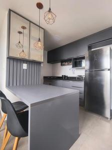 a kitchen with a counter and a refrigerator at Flat PREMIUM em Manaíra - Sun Beach in João Pessoa