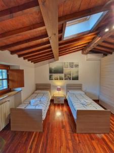 two beds in a room with wooden floors at Villa Castaldi Firenze vicina al centro in Florence