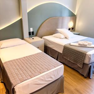 a hotel room with two beds in a room at Hotel Zata e Flats in Criciúma