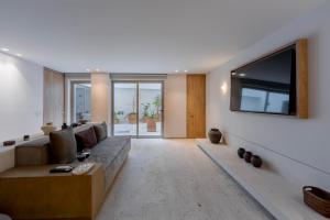 a living room with a couch and a flat screen tv at Capitalia Reforma Chapultepec in Mexico City