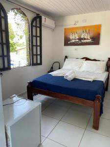 a bedroom with a bed with blue sheets and a window at Recanto do caja in Porto De Galinhas +44 photos