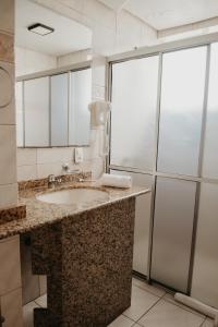 a bathroom with a sink and a shower at Hotel Letto Caxias in Caxias do Sul +29 photos