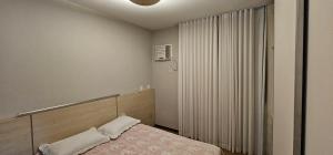 a small bedroom with a bed and a window at Charme e Conforto na Savassi in Belo Horizonte +44 photos