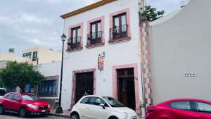 two cars parked in front of a white building at Cinco de Mayo Hotel in Querétaro +32 photos