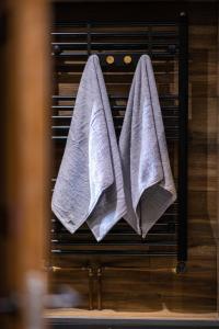 two towels are hanging on a drying rack at Apartman ALPINA Bogatic in Bogatić +20 photos