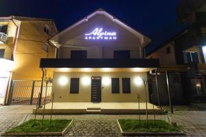 a building with a sign on the front of it at Apartman ALPINA Bogatic in Bogatić