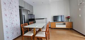 a kitchen with a table and chairs and a refrigerator at Charme e Conforto na Savassi in Belo Horizonte