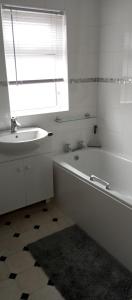 a white bathroom with a tub and a sink at Lilypad in Devizes