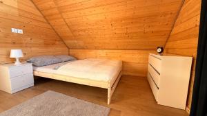 a bedroom with a bed in a wooden cabin at Cud Miód Mazury in Bogaczewo
