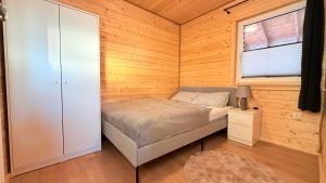 a small bedroom with a bed and a window at Cud Miód Mazury in Bogaczewo