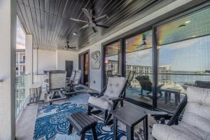 a screened in porch with chairs and a table at Family Tides Condo for 8 in Osage Beach