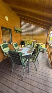 a patio with a table and chairs on a deck at Cud Miód Mazury in Bogaczewo