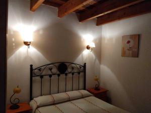a bedroom with a bed with two lights on the wall at La Casa del Acebal (Solorzano - Cantabria) in Solórzano