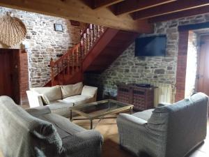 a living room with couches and a table and a tv at La Casa del Acebal (Solorzano - Cantabria) in Solórzano