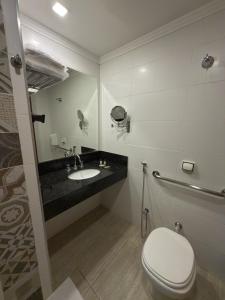 a bathroom with a toilet and a sink at Tamareiras Prime Hotel in Uberaba