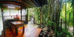 a room with a wooden table and a room with trees at EcoLodge La Pluma in Salento +98 photos