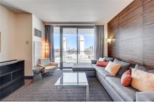 a living room with a couch and a large window at Palms Place in Las Vegas