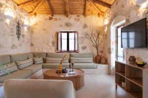 a living room with a couch and a tv at Paliokaliva Apartments and Villas in Tsilivi
