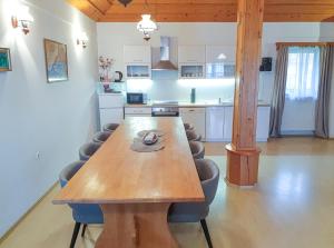 a wooden table in a kitchen with chairs around it at Apartment Feher Lendava in Lendava