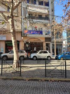 a street with cars parked in front of a building at Barbie in Veria