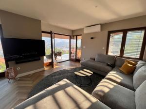 a living room with a couch and a flat screen tv at The Penthouse Sarajevo in Sarajevo