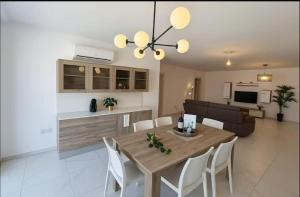a dining room and living room with a table and chairs at Marija Block St Julian's Apartments in Is-Swieqi
