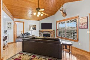 a living room with a couch and a tv at Blue Sky Lodge For 4 in Branson West