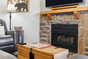 a living room with a fireplace with a television on top at Blue Sky Lodge For 4 in Branson West +15 photos