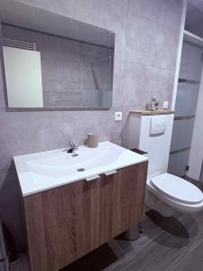 a bathroom with a white sink and a toilet at Le Paradis d'Ayli in Aywaille