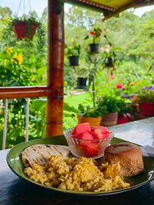 a plate of food with bread and fruit on a table at EcoLodge La Pluma in Salento