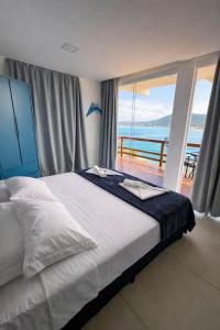 a bedroom with a bed with a view of the ocean at Pousada Vista Grega in Arraial do Cabo +161 photos