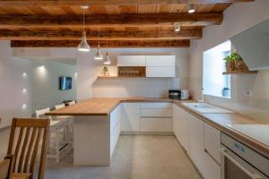 a kitchen with white cabinets and a wooden ceiling at Villa Gino in Pazin
