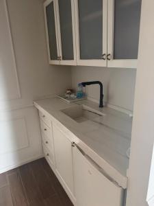 a kitchen with white cabinets and a sink at סוויטת דופלקס על הים בבת ים in Bat Yam