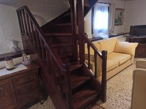 a wooden staircase in a living room with a couch at FAVIEROS-The secret Garden in Mesochórion