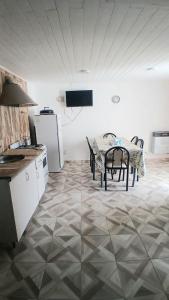 a kitchen with a table and chairs and a refrigerator at La Mejor-A in Comandante Luis Piedra Buena
