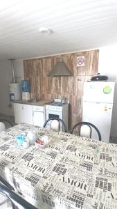a kitchen with a table and a refrigerator at La Mejor-A in Comandante Luis Piedra Buena