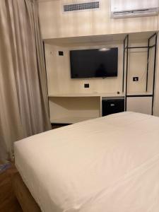 a bedroom with a bed and a flat screen tv at חדר על הים בבת ים in Bat Yam