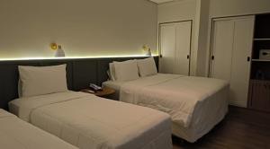 a hotel room with two beds and a table at Hotel Fazenda Brisa Itu in Itu