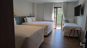 a hotel room with two beds and a tv at Hotel Fazenda Brisa Itu in Itu