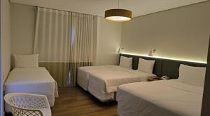 a hotel room with two beds and a chair at Hotel Fazenda Brisa Itu in Itu +94 photos