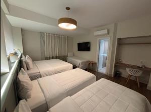 a hotel room with two beds and a television at Hotel Fazenda Brisa Itu in Itu