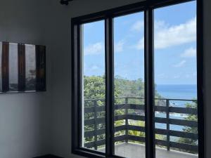 a room with a window looking out at the ocean at Villa Sete Ondas in Ribeira Afonso +5 photos