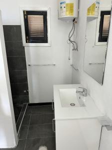 a small bathroom with a sink and a mirror at Villa Sete Ondas in Ribeira Afonso
