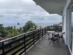 a balcony with a table and chairs and the ocean at Villa Sete Ondas in Ribeira Afonso