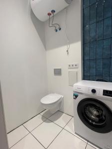 a white bathroom with a toilet and a washing machine at Hubane korter Kiviõlis in Kiviõli