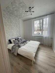 a bedroom with a large bed with a ceiling at Hubane korter Kiviõlis in Kiviõli
