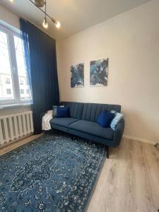 a living room with a blue couch and a blue rug at Hubane korter Kiviõlis in Kiviõli