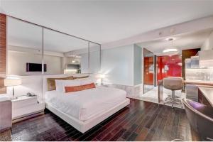 a bedroom with a large white bed with a glass wall at Palms Place in Las Vegas +68 photos