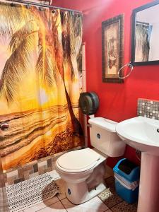 a bathroom with a palm tree shower curtain and a toilet at Hotel Sueños de María in Uvita +59 photos