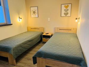 a room with two beds and a table and a window at Barrierefreie Ferienwohnung Abendrot in Pewsum, 1 - 4 Personen in Krummhörn